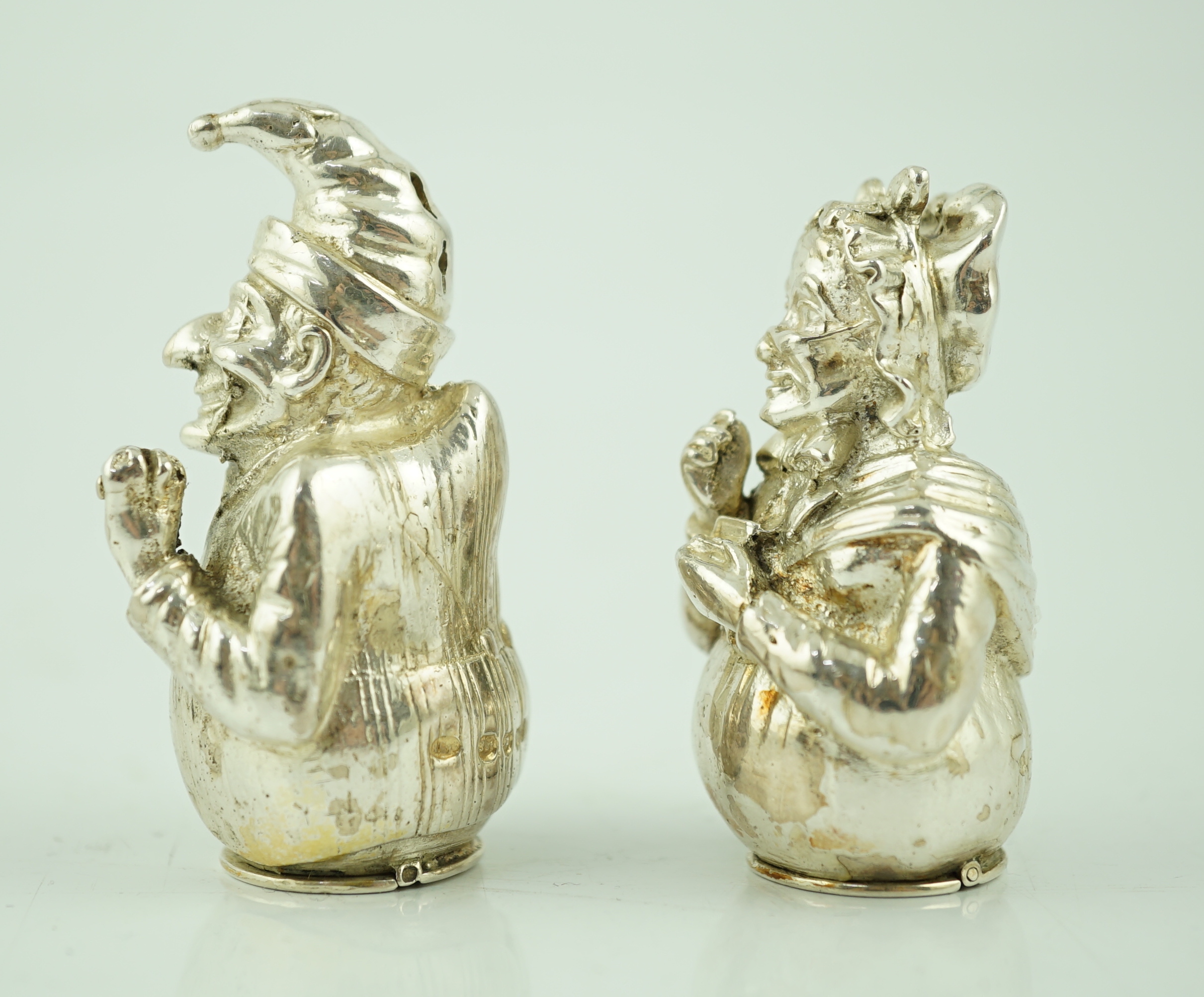 A pair of cast late Victorian novelty silver pepperettes, modelled as Punch and Judy, Edward H. Stockwell